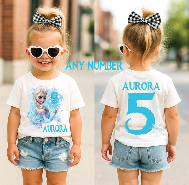 Pu&ograve; includere: Maglietta bianca con grafica di personaggio dei cartoni animati e il numero 5 in blu. Il nome "Aurora" &egrave; stampato sul davanti e sul retro. &Egrave; visibile anche il testo "ANY NUMBER".