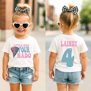 May include: A white t-shirt with the text "LITTLE MISS FOUR NADO" and a cartoon tornado graphic. The back of the shirt has the name "LAINEY" and the number "4". The child is wearing denim shorts and heart-shaped sunglasses.