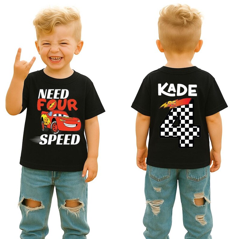 Op de afbeelding: Een zwart T-shirt met korte mouwen, voorzien van een rode raceauto-afbeelding met de tekst "NEED FOUR SPEED" op de voorzijde en de naam "KADE" boven een groot geblokt cijfer "4" op de achterzijde, gedragen door een kind in een lichtblauwe jeans.