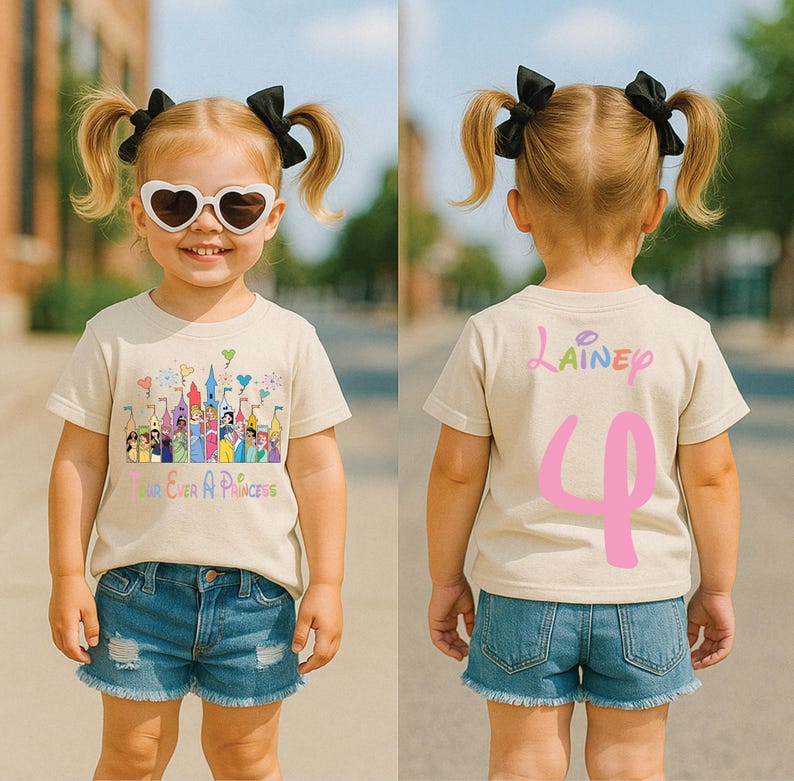 May include: A beige t-shirt with a colorful castle graphic and the text "Forever A Princess." The back of the shirt has the name "Lainey" and the number "4" in pink. The child is wearing denim shorts and heart-shaped sunglasses.