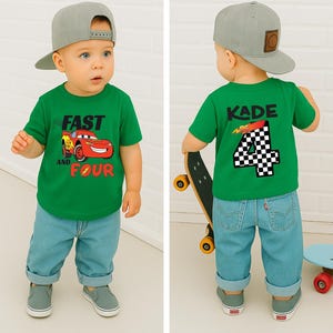 Pu&ograve; includere: Una t-shirt verde a maniche corte con la grafica di un'auto da corsa rossa e la scritta FAST AND FOUR sul davanti, e il nome KADE con il numero 4 a scacchi sul retro, abbinata a jeans azzurri e un cappellino da baseball grigio.