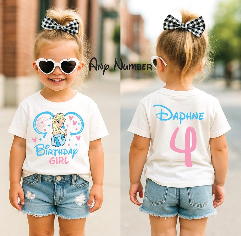 May include: A white short-sleeved t-shirt featuring a graphic of a blonde character in a blue dress with the text Birthday Girl on the front and the name Daphne with the number 4 on the back, paired with blue denim shorts and a black and white bow.
