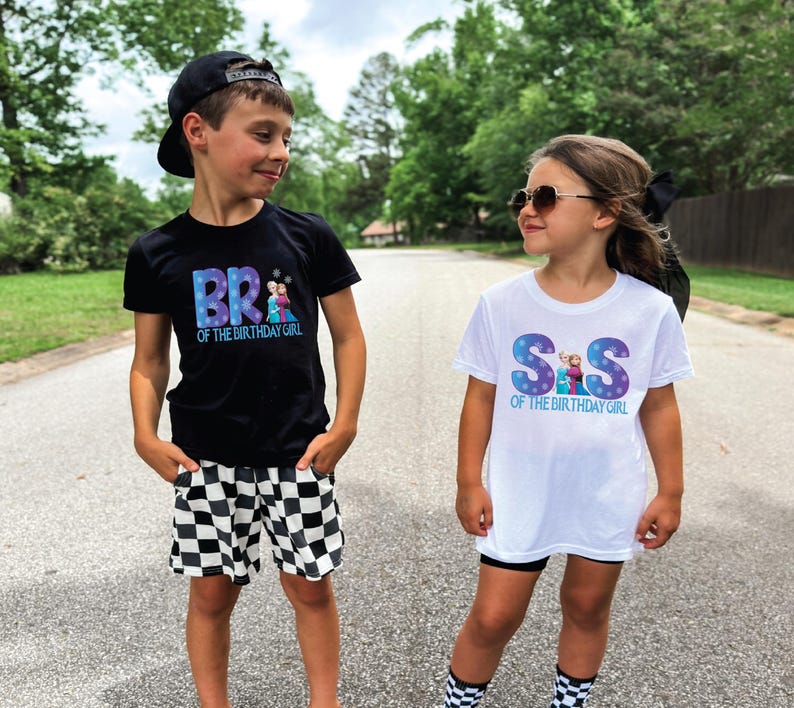 K&ouml;nnte beinhalten: Zwei Kinder tragen passende Geburtstags-T-Shirts. Ein Kind tr&auml;gt ein schwarzes Shirt mit dem Text "BR of the Birthday Girl" und karierten Shorts. Das andere Kind tr&auml;gt ein wei&szlig;es Shirt mit dem Text "S&S of the Birthday Girl".
