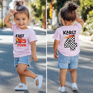 Pu&ograve; includere: Una t-shirt a maniche corte rosa chiaro con una grafica di auto da corsa rossa e il testo FAST AND FOUR sul davanti, e il nome KARLY sopra un grande numero 4 a scacchi con un fulmine sul retro, abbinata a pantaloncini di jeans blu.