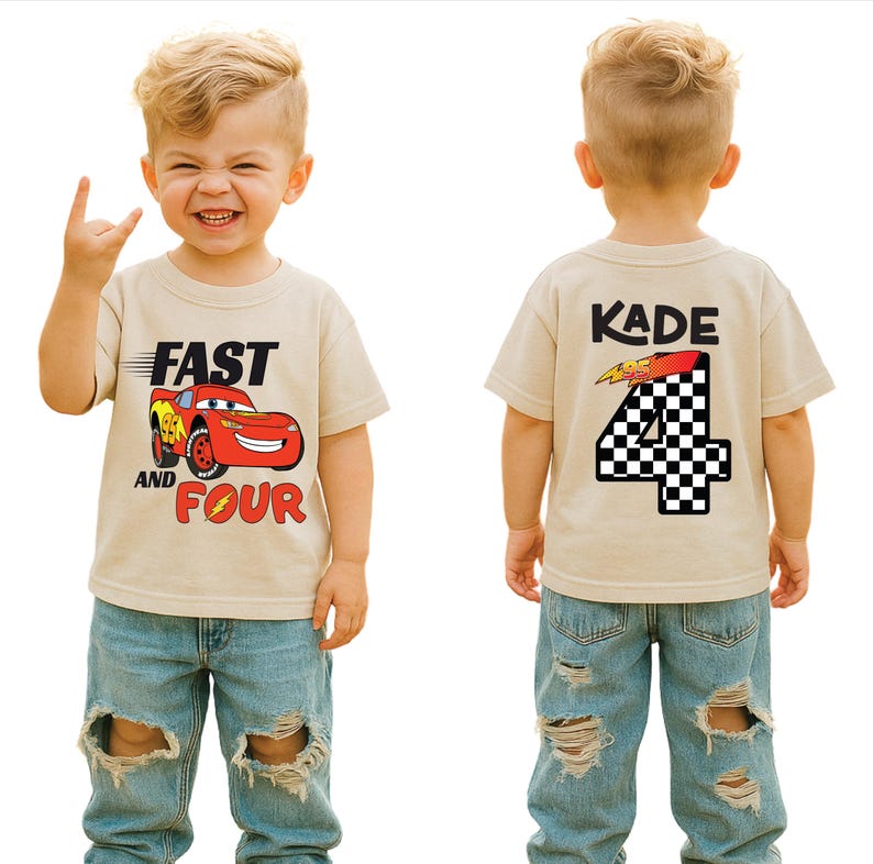 Pu&ograve; includere: Una t-shirt beige a maniche corte con una grafica di auto da corsa rossa sul davanti con il testo FAST AND FOUR. Il retro della maglietta mostra il nome KADE sopra un grande numero 4 con un motivo a scacchi bianco e nero e un fulmine.