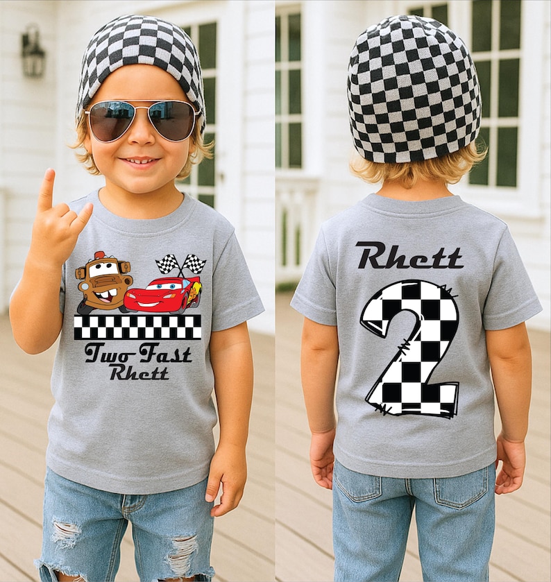 May include: A gray t-shirt with a race car design and the text "Two Fast Rhett" on the front. The back of the shirt features a large number "2" in a checkered pattern and the name "Rhett". The child is wearing a checkered beanie and sunglasses.