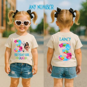 May include: A beige t-shirt with a colorful floral number 3 design and the text "BIRTHDAY GIRL". The shirt features a cartoon character. The back of the shirt has the name "LAINEY" and a floral number 3.