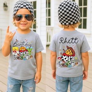 May include: A gray t-shirt with the words "Birthday BOY" and Toy Story characters. The back of the shirt has the name "Rhett" and more Toy Story graphics. The child is wearing a black and white checkered beanie and sunglasses.