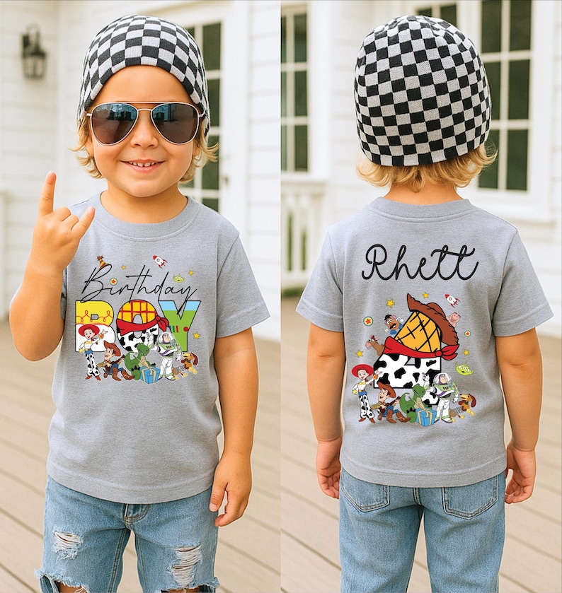 May include: A gray t-shirt with the words "Birthday BOY" and Toy Story characters. The back of the shirt has the name "Rhett" and more Toy Story graphics. The child is wearing a black and white checkered beanie and sunglasses.