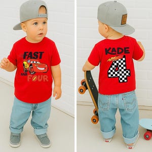 Pu&ograve; includere: Una t-shirt rossa a maniche corte con la grafica di un'auto da corsa rossa e la scritta Fast and Four sul davanti, e il nome Kade con il numero 4 a scacchi sul retro, abbinata a jeans azzurri e un berretto da baseball grigio.