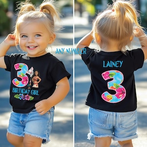 May include: Black t-shirt with a floral number 3 and the text "BIRTHDAY GIRL" and a cartoon image. The back of the shirt has the name "Lainey" and a floral number 3. The child is wearing blue jean shorts.