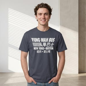 May include: A navy blue t-shirt with white text that reads "FUNG WAH BUS" in a bold font. Below the text are Chinese characters and the words "NEW YORK • BOSTON". The shirt is a crew neck and is being worn by a person.