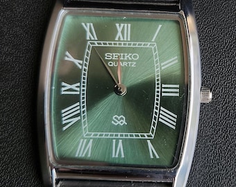 Relógio Seiko Slim vintage restaurado, com mostrador verde, movimento de quartzo e pulseira de malha: estilo clássico retangular.