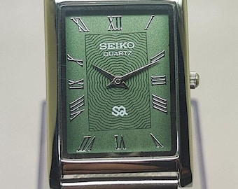 Relógio Seiko Slim vintage restaurado, com mostrador verde, movimento de quartzo e pulseira de malha: estilo clássico retangular.