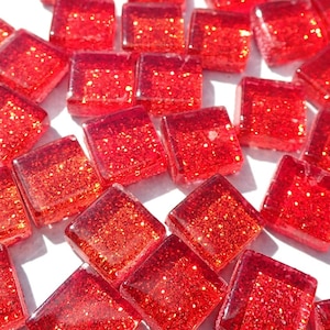 May include: A collection of red glass mosaic tiles with a glittery finish. The tiles are square shaped and have a translucent appearance.