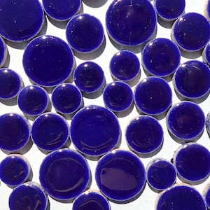 May include: A collection of round, blue ceramic tiles. The tiles are various sizes and have a glossy finish.