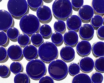 May include: A collection of round, blue ceramic tiles. The tiles are various sizes and have a glossy finish.