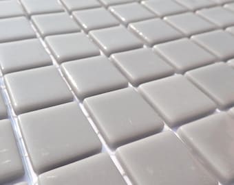May include: Close-up of a grid of square, light gray tiles. Each tile has rounded edges and a glossy finish. The tiles are evenly spaced, creating a repeating pattern. The overall effect is smooth and modern, suitable for various design applications.