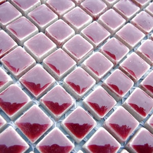 May include: Close-up of a mosaic tile sheet. The tiles are square, with a diamond orientation, and are arranged in a grid pattern. Each tile has a glossy, burgundy-colored top and a light gray border. The tiles are suitable for interior design.