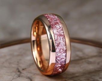May include: A rose gold ring with a band of crushed pink gemstones. The ring has a polished finish and the text "MERRYGEMSSTUDIO" is visible in the upper left corner. The ring is set against a neutral background.