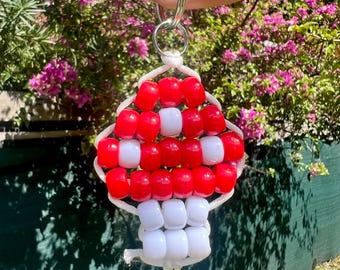 May include: A mushroom-shaped keychain crafted from red and white plastic pony beads strung on white cord. The cap features a pattern of red and white beads, while the stem is constructed from white beads. A silver metal split ring is attached at the top.
