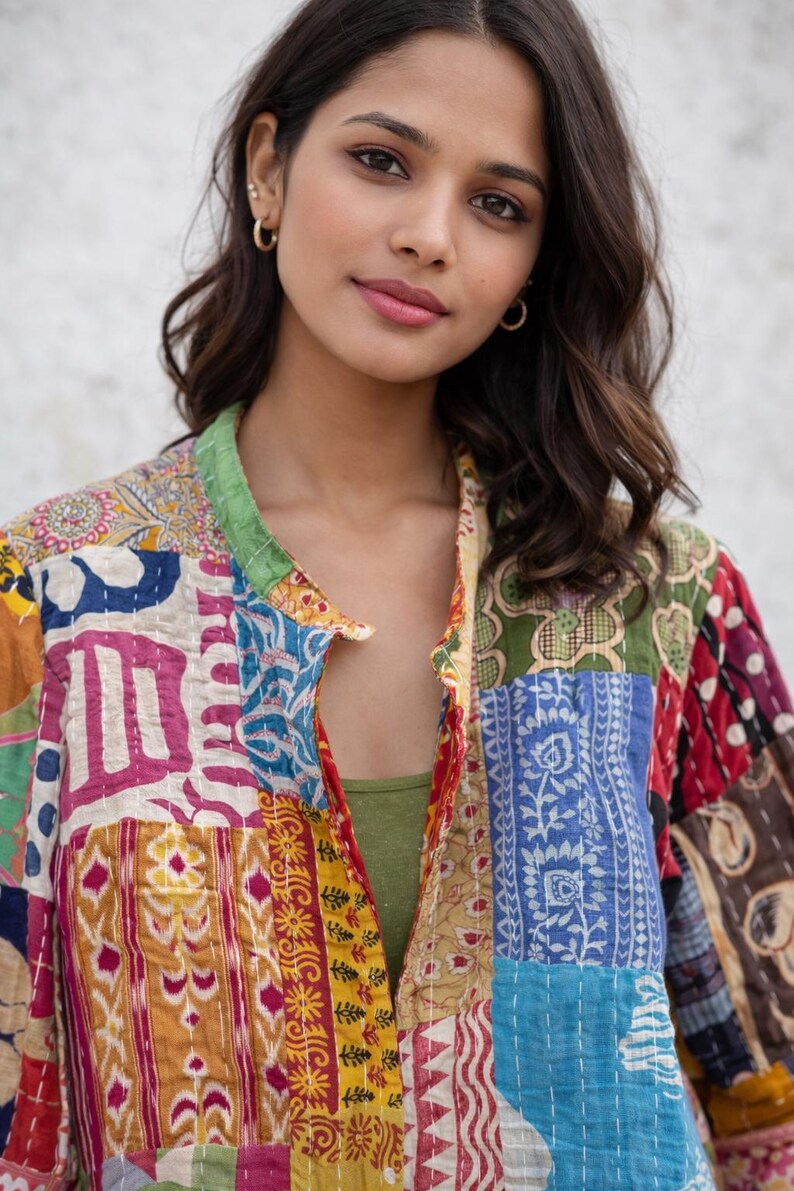 May include: A colorful patchwork jacket with a green collar and a variety of patterned fabric squares. The jacket is open, revealing a green top underneath. The jacket's design includes shades of blue, yellow, red, and white.