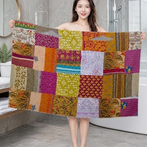 Könnte beinhalten: Ein rechteckiges Textil mit einem Patchwork-Design, das aus verschiedenen Stoffquadraten in den Farben Magenta, Senfgelb, Olivgrün und Lavendel besteht. Der Stoff zeigt verschiedene florale, geometrische und abstrakte Muster mit sichtbaren Nähten.