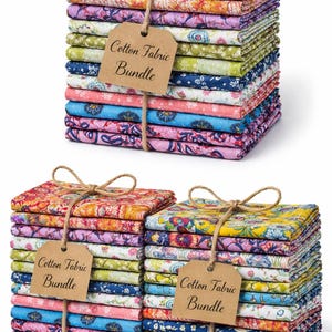 Puede incluir: Varias pilas de paquetes de tela de algodón estampada, atadas con hilo. La tela muestra diseños florales en amarillo, rosa, azul y verde. Cada paquete está etiquetado como "Cotton Fabric Bundle".