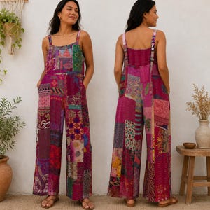 Può includere: Una tuta patchwork nei toni del rosa, rosso e viola. La tuta a gamba larga presenta uno scollo quadrato, spalline regolabili e tasche. Il tessuto è composto da varie toppe fantasia, creando un design unico e colorato. La modella indossa sandali.