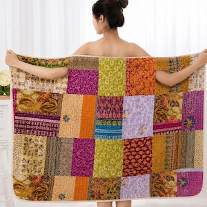 Könnte beinhalten: Eine rechteckige Patchwork-Decke mit einer Vielzahl lebendiger Stoffquadrate in Magenta, Senfgelb, Limettengrün und Orange. Das Textil zeigt verschiedene komplexe Muster, darunter florale, Paisley- und geometrische Designs auf der gesamten Oberfläche.