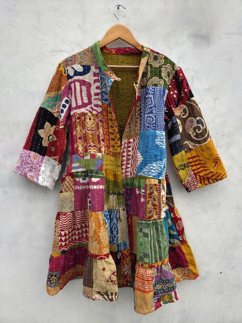May include: A patchwork jacket with a variety of colorful fabric patterns. The jacket features a collar and long sleeves. The design includes a mix of floral, geometric, and abstract shapes in shades of red, blue, yellow, and green.