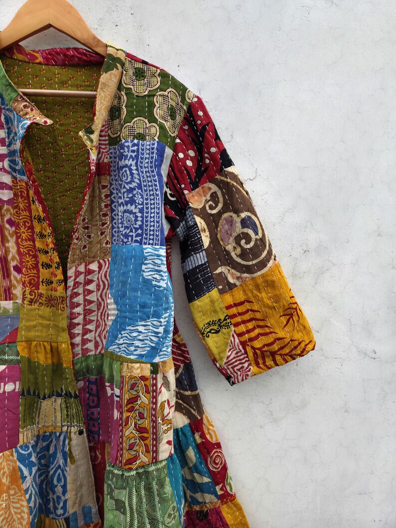 May include: A patchwork jacket with a variety of colorful fabric patterns. The jacket features a collared neckline and long sleeves. The design includes red, blue, yellow, and green patches, creating a vibrant and unique look.