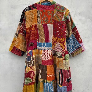 May include: A patchwork jacket with a variety of colorful fabric squares. The jacket has three-quarter sleeves and a tiered design. The colors include red, orange, yellow, blue, and green.