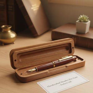 May include: A wooden pen case with a dark brown fountain pen. The pen has gold accents and a gold nib. The case is open, revealing the pen inside. A small card reads "Handcrafted Wooden Pen Case - Perfect Gift".