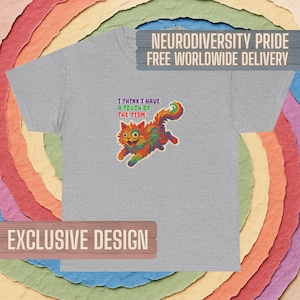May include: A heather gray t-shirt featuring a colorful, rainbow-patterned cat illustration in the center. Above the cat, the text reads: I THINK I HAVE A TOUCH OF THE 'TISM. The design is printed on the front of the short-sleeved crew neck garment.