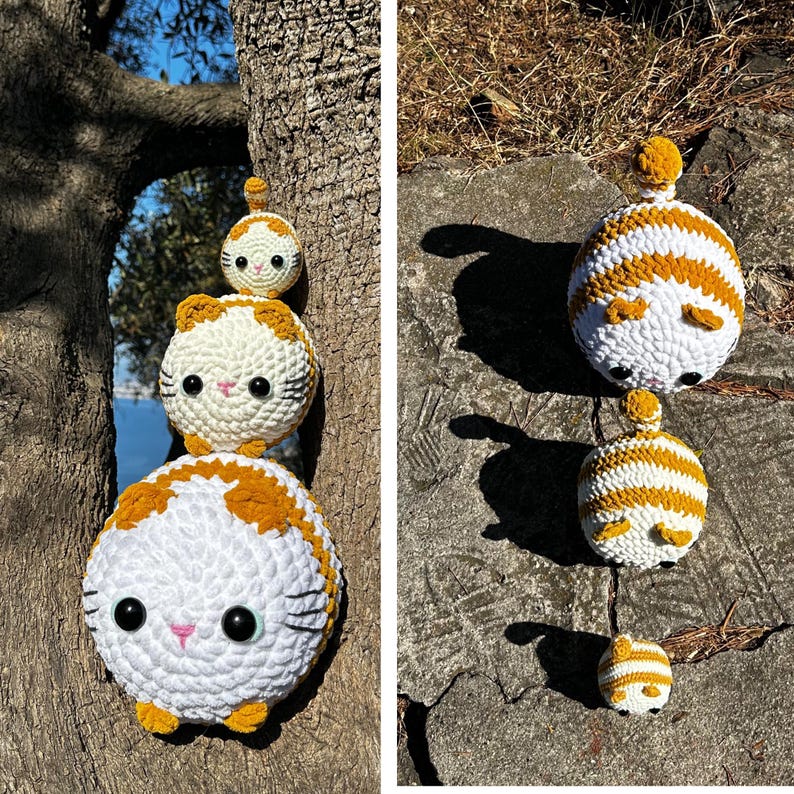 May include: Crocheted cat plush toys in white and orange. The toys are stacked on a tree and a rock. The cats have black eyes, pink noses, and yellow ears and paws. The toys are handmade and have a round shape.