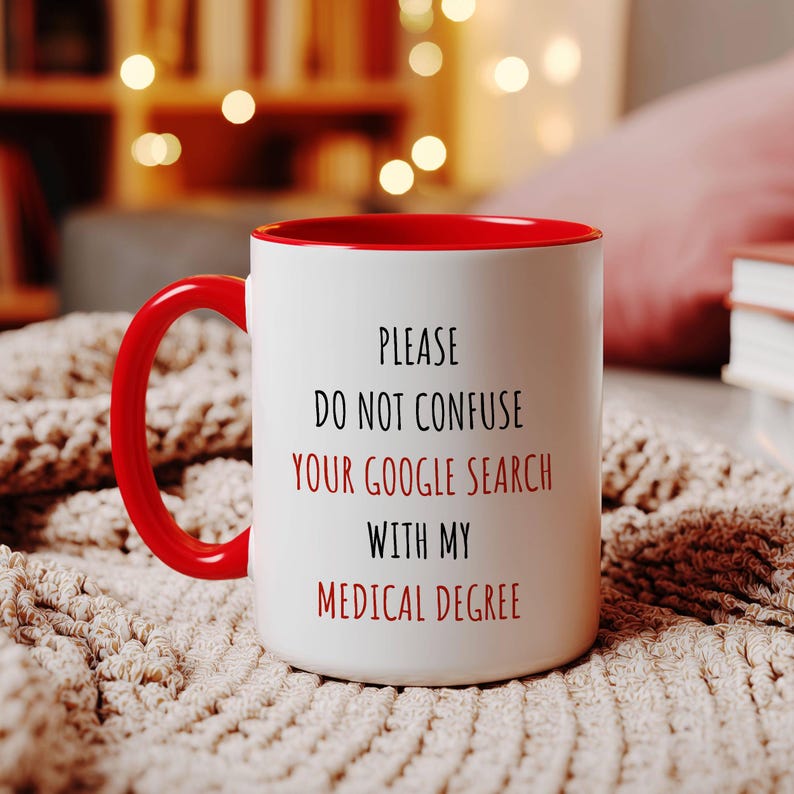 White ceramic mug with a red handle and interior, featuring 'PLEASE DO NOT CONFUSE YOUR GOOGLE SEARCH WITH MY MEDICAL DEGREE' in red and black.