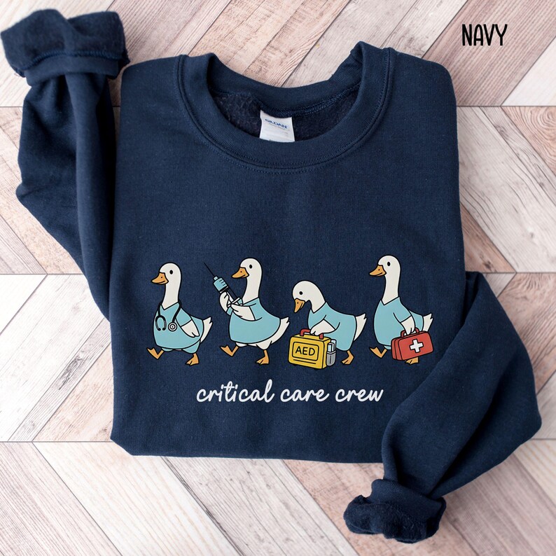 A "Navy" sweatshirt, featuring four cartoon geese dressed as an ICU medical team, with the text "critical care crew" printed below.