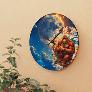 Könnte beinhalten: Runde Wanduhr mit einer detaillierten Illustration eines Orang-Utans, der eine Orange hält, vor einem himmlischen Hintergrund mit einem großen Mond und Wolken. Die Uhrzeiger sind schwarz, und das Design enthält chinesische Schriftzeichen.