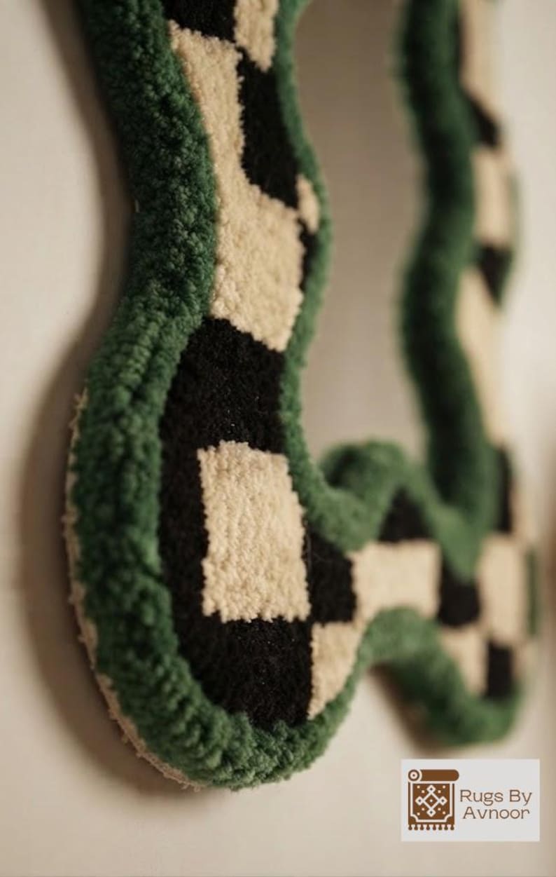 Close-up side view of a handmade tufted mirror frame showing plush New Zealand wool texture and carved edges.