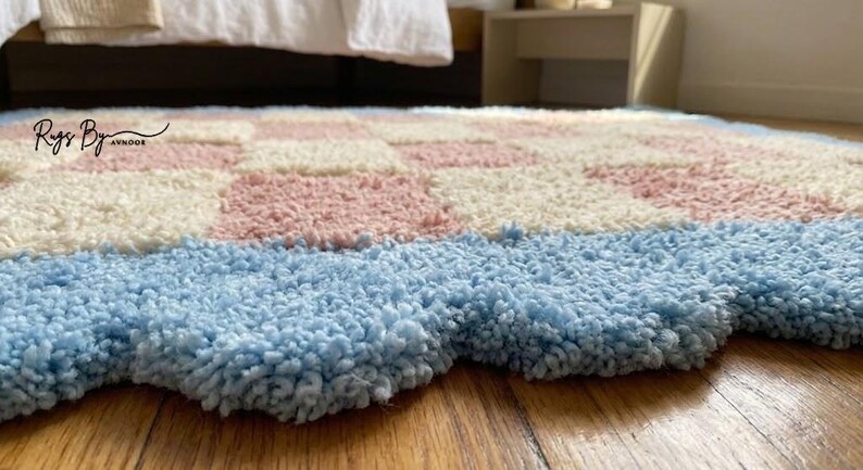 Close-up view of the scalloped blue border showing plush tufted wool texture.