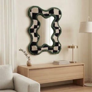 Organic checkerboard tufted wall mirror styled above a wooden console in a modern living room.