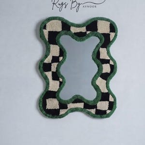Handmade organic wavy checkerboard mirror hanging on a plain wall, highlighting the sculptural tufted frame.