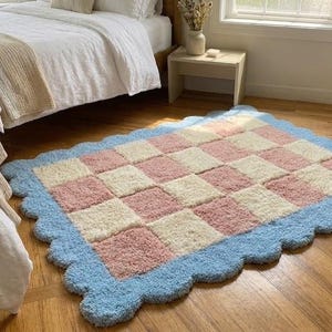 Lifestyle image of the rug placed beside a bed in a cozy pastel bedroom.