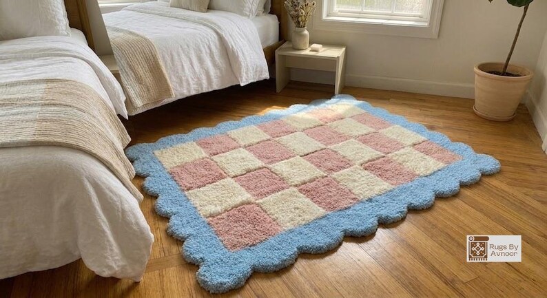 Lifestyle image of the rug placed beside a bed in a cozy pastel bedroom.
