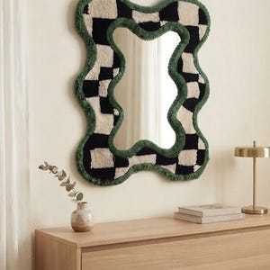 Modern interior featuring a black and cream checkerboard tufted mirror as a statement wall decor piece.
