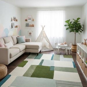 May include: A modern living room with a beige sectional sofa, a geometric patterned rug in shades of green, blue, and white, and a small teepee. The room is decorated with shelves, a small table and chairs, and a potted plant.