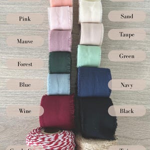 May include: An assortment of fabric ribbons and twine in various colors, including peach, pink, mauve, forest green, blue, wine, black, cream, sand, taupe, green, and navy. A roll of red and white candy cane twine and a roll of natural twine are also visible.