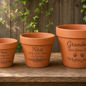 May include: Three terracotta plant pots of varying sizes, each featuring black printed text and botanical illustrations. The smallest reads Mum Thank You For Helping Me Grow, the middle Nan If Nans Were Flowers I'd Pick You, and the largest Grandma Love Grows Here.