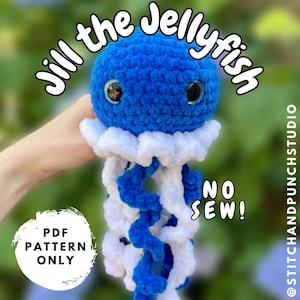 Op de afbeelding: Een blauw en wit gehaakt kwal speelgoed. De kwal heeft grote, ronde ogen en lange, vloeiende tentakels. De afbeelding bevat de tekst "Jill the Jellyfish", "PDF Pattern Only" en "NO SEW!".
